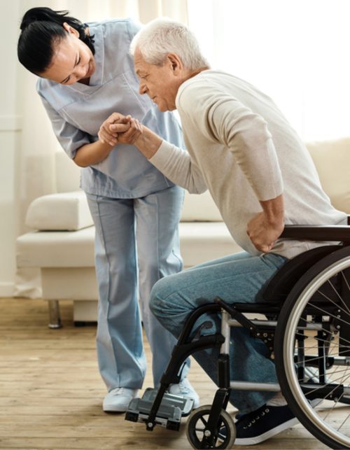 Physical disability. Nice sad aged man holding a caregivers hand and trying to get up while having a physical disability
